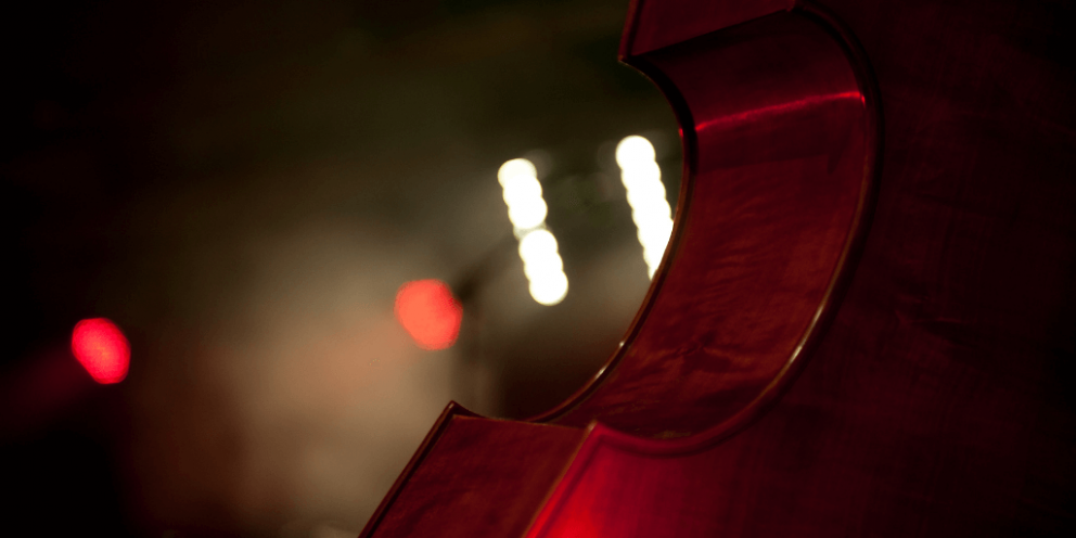 Part of a cello with blurry lights in background