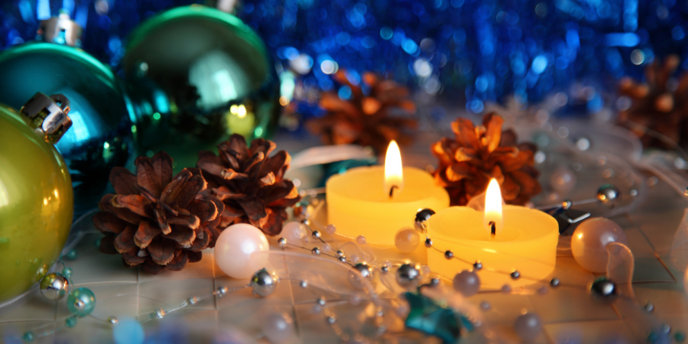 Yellow candles with Christmas decorations and pinecones