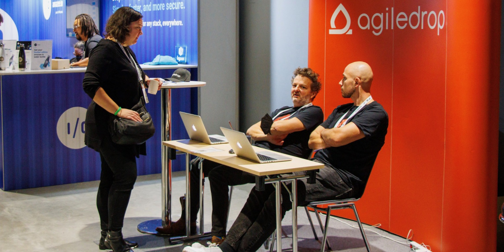 Aleš & Jure at DrupalCon Prague 2022 at Agiledrop booth talking to attendee
