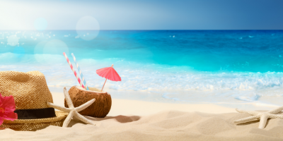 The beach with straw hat, coconut drink with straw and paper umbrella, and starfish