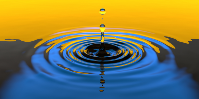 Drop falling into still water and creating ripples