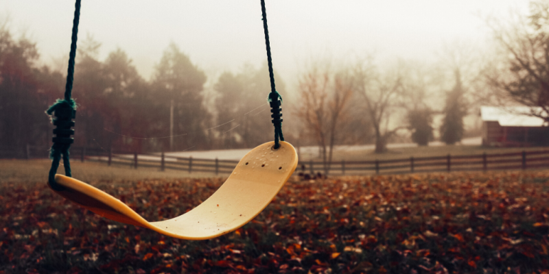 Abandoned yellow swing in empty park