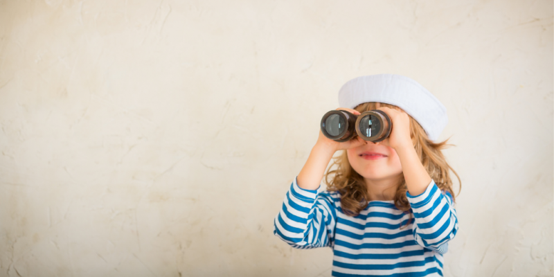 Girl in sailor shirt and hat looking through binoculars